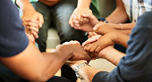 People holding hands together during a support group meeting