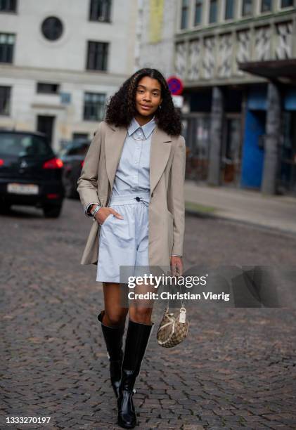 Guest is seen wearing blue shorts and button shirt, blazer, Louis Vuitton bag, black white boots outside Day Birger et Mikkelsen on August 09, 2021...