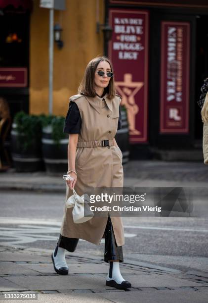 Gosia Boy is seen wearing beige trench coat, white bag, black white ankle boots outside Vanessa Hong x Birgitte Herskind SS22 preview on August 09,...