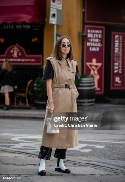 Gosia Boy is seen wearing beige trench coat, white bag, black white ankle boots outside Vanessa Hong x Birgitte Herskind SS22 preview on August 09,...