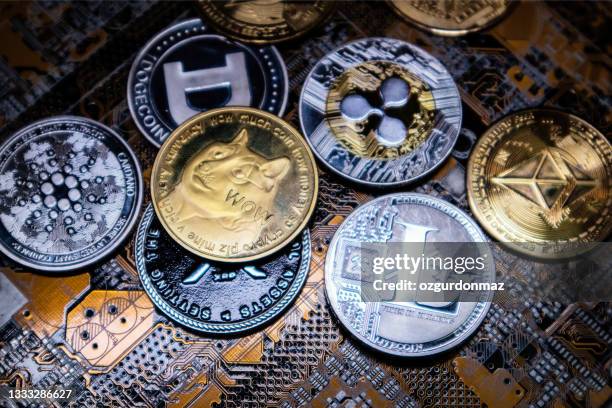 close up shot of alt coins cryptocurrency over computer circuit - altcoins imagens e fotografias de stock