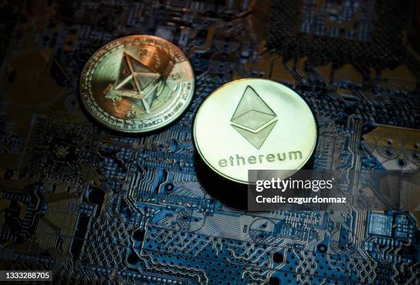 close-up of ethereum eth cryptocurrency over computer circuit - ethereum stockfoto's en -beelden