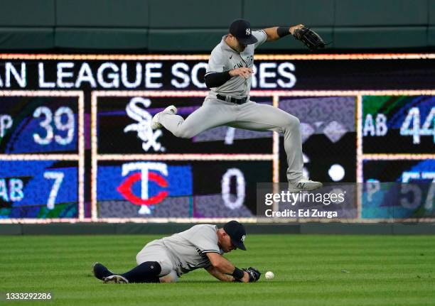 Joey Gallo of the New York Yankees leaps over Brett Gardner going for a ball off the bat of Cam Gallagher of the Kansas City Royals in the third...