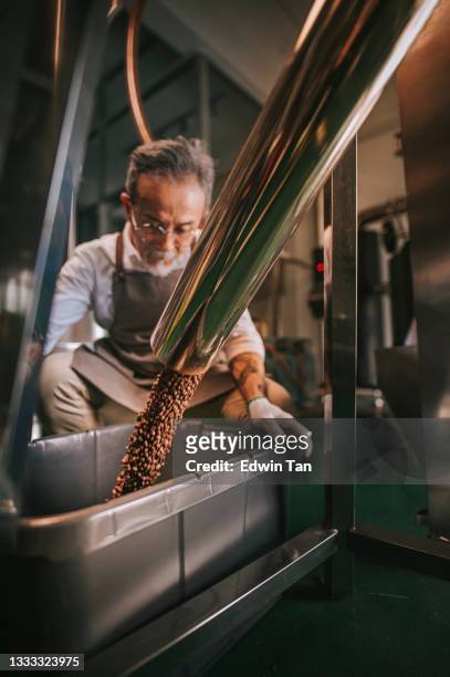artesão chinês chinês examinando o processo de remoção de pedra de feijão torrado após girar para fora do processo de resfriamento em sua fábrica - mini fábrica de cerveja - fotografias e filmes do acervo