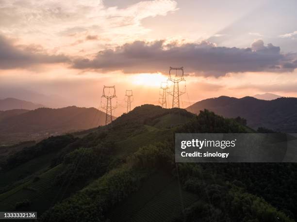 high voltage pole during sunset - power mast stock pictures, royalty-free photos & images