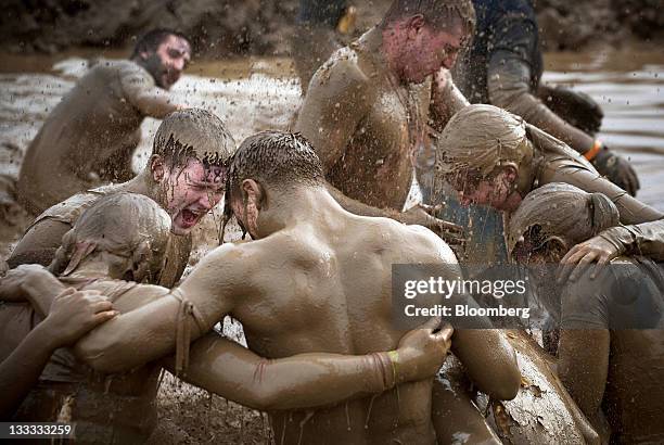 Participants slog through the mud mile obstacle during the Tough Mudder endurance challenge at Raceway Park in Englishtown, New Jersey, U.S., on...