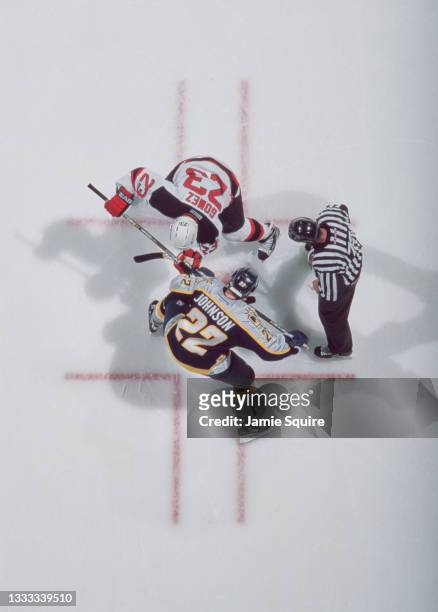The Referee prepares to drop the puck as Scott Gomez, Center for the New Jersey Devils and Greg Johnson of the Nashville Predators get set for the...