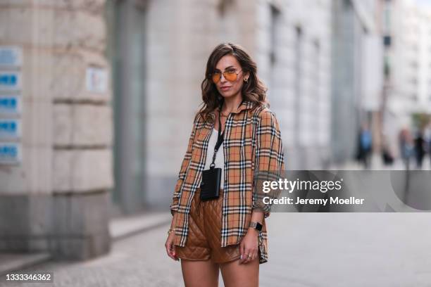 Masha Sedgwick wearing Burberry flanell, Bottega Veneta black mini bag, ApParis beige leather shorts, Arket top and Rayban shades on August 06, 2021...