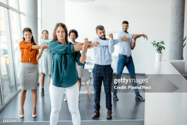 businesspeople doing stretching exercise at workplace - sports period bildbanksfoton och bilder