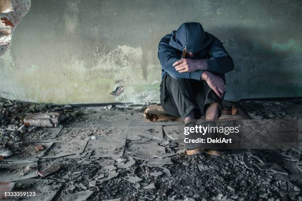 drug addict in crisis sitting in abandoned house - drug rehab stockfoto's en -beelden