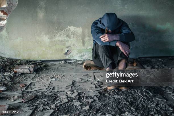 drug addict in crisis sitting in abandoned house - addiction recovery stock pictures, royalty-free photos & images