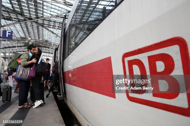 Passengers embrace as people prepare to board an Intercity Express train at Berlin's main train station, or Hauptbahnhof, on August 10, 2021 in...