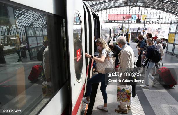 Passengers board an Intercity Express train at Berlin's main train station, or Hauptbahnhof, on August 10, 2021 in Berlin, Germany. Ninety-five...