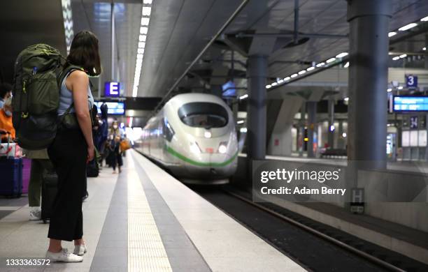 Passenger looks on as an Intercity Express high-speed train approaches at Berlin's main train station, or Hauptbahnhof, on August 10, 2021 in Berlin,...