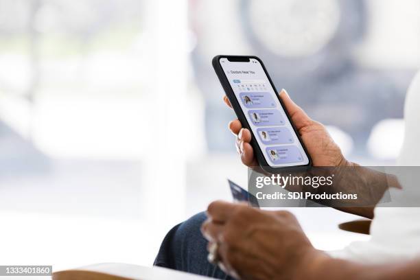 senior woman uses credit card to pay for tele-medicine appointment - smartphone screen stockfoto's en -beelden