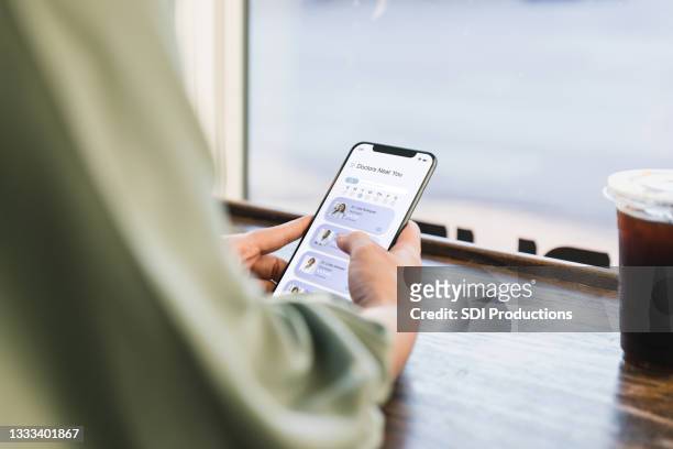 young adult woman surfs net for doctor - telemedicine patient stock pictures, royalty-free photos & images