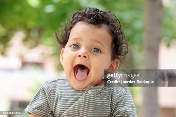 funny baby sticking out his tongue, outdoors - crimped hair imagens e fotografias de stock