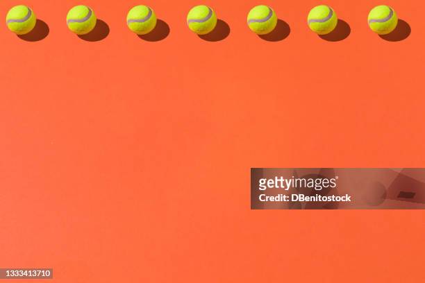 yellow tennis balls pattern with hard shadow on top line on orange background. sport and tennis concept - tennis ball imagens e fotografias de stock