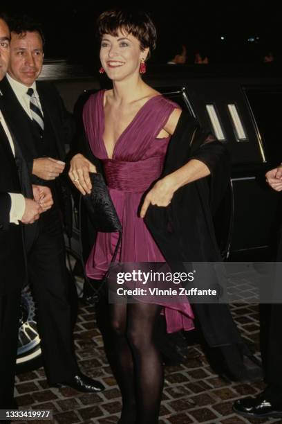 British actress Amanda Donohoe, wearing a purple dress with a plunging neckline and a black wrap, attends the 49th Annual Golden Globe Awards, held...