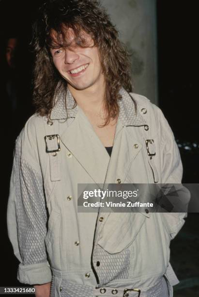 British musician and songwriter Andy Taylor wearing a light grey jacket with buckles on the chest, location unspecified, circa 1990. Taylor is a...