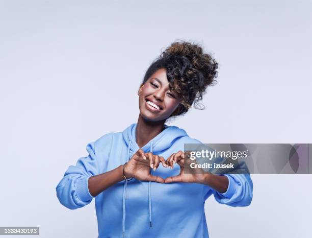 cheerful young woman showing love sign - finger bun stock pictures, royalty-free photos & images