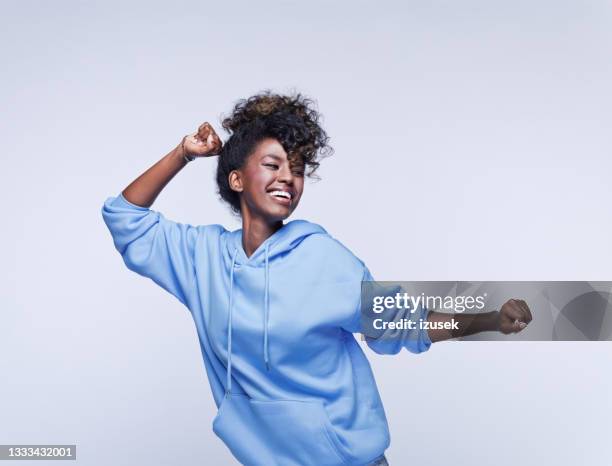 青いパーカーで踊る若い女性 - hooded shirt ストックフォトと画像