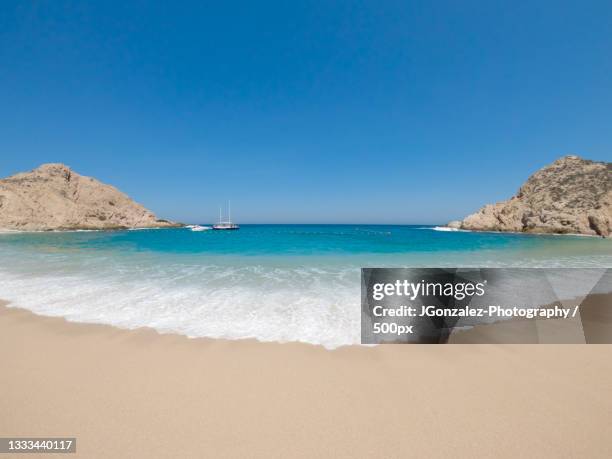 scenic view of beach against clear blue sky,cabo san lucas,baja california sur,mexico - cabo san lucas stockfoto's en -beelden