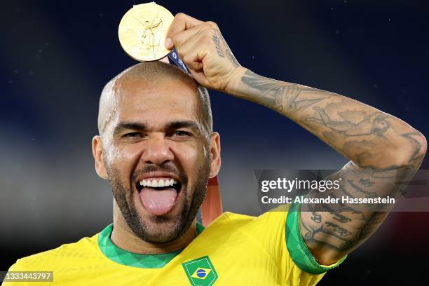 Gold medalist Dani Alves of Team Brazil celebrates with their gold medal during the Men's Football Competition Medal Ceremony on day fifteen of the...