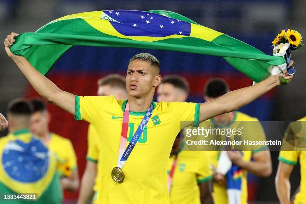 Richarlison of Team Brazil celebrates their side's victory with a flag of Brazil after the Men's Gold Medal Match between Brazil and Spain on day...