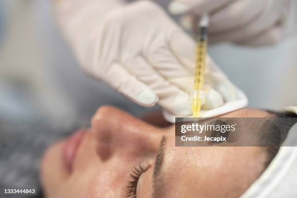 primer plano de la cara de la paciente femenina durante el tratamiento con hialuronano - plasma rico en plaquetas fotografías e imágenes de stock