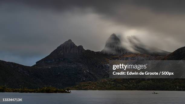 scenic view of lake and mountains against sky,cradle mountain,tasmania,australia - cradle mountain stock-fotos und bilder