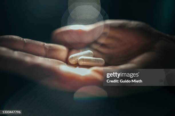 hands holding medical pills in dramatic light. - anti depressant stock pictures, royalty-free photos & images