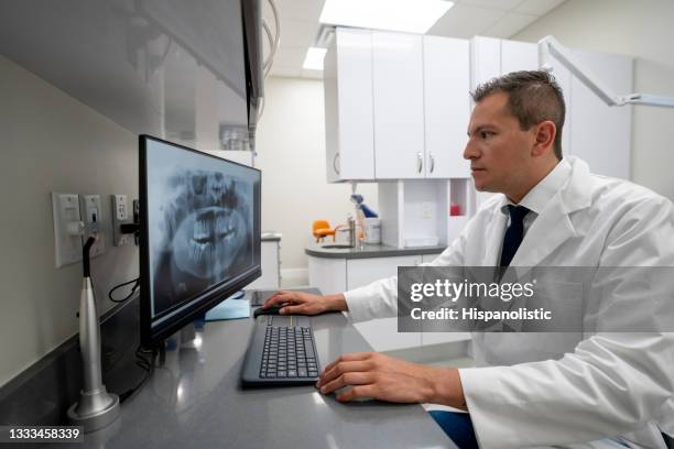médico mirando una radiografía dental en la computadora - radiologia dental fotografías e imágenes de stock