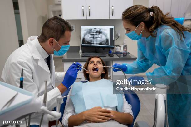 woman at the dentist getting her teeth sorted - parodontitis stockfoto's en -beelden