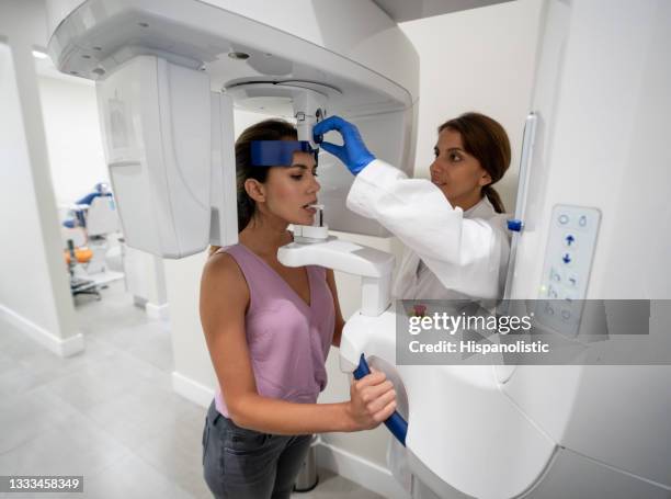 woman getting an x-ray of her teeth at a dental clinic - periodontal disease stock pictures, royalty-free photos & images