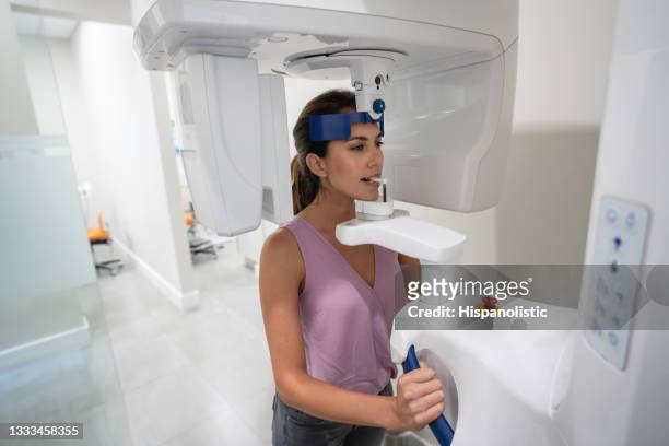 patient at a dental clinic getting an x-ray of her teeth - medical scanning equipment stock pictures, royalty-free photos & images