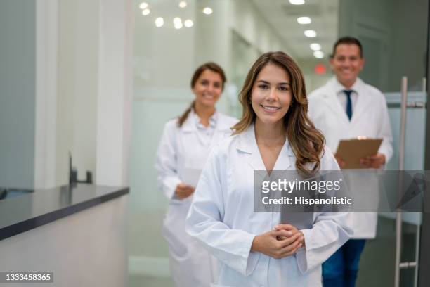 happy group of latin doctors working at a clinic - service management stockfoto's en -beelden