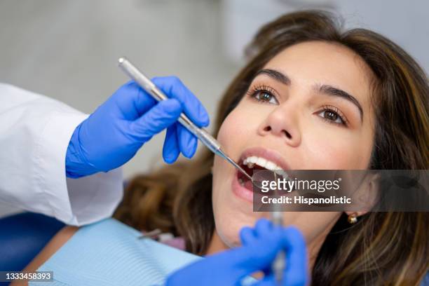 patientin beim zahnarzt, der ihre zähne reinigen lassen - zahnarztausrüstung stock-fotos und bilder
