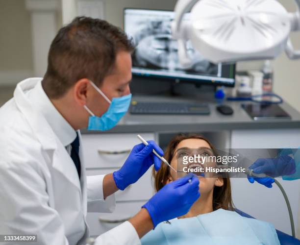 dentist doing a dental procedure to a female patient - man open mouth stock pictures, royalty-free photos & images