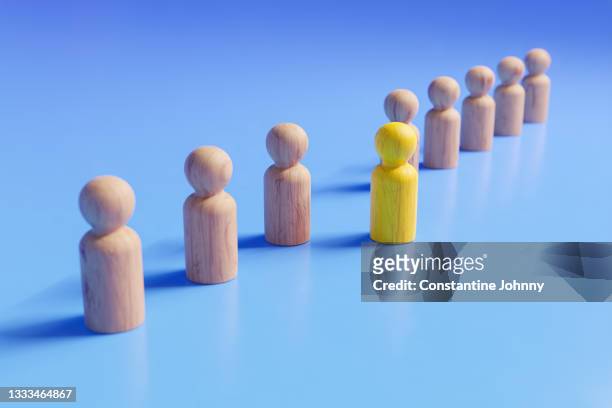 stepping out to be different. teamwork and leadership concepts with wooden people figures. - people capability digital yellow stock-fotos und bilder