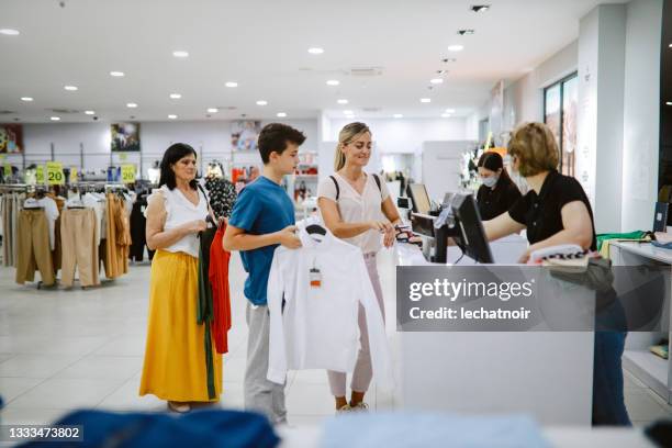 frau ende 30 bezahlt kontaktlos im einkaufszentrum - teenager boy shopping stock-fotos und bilder