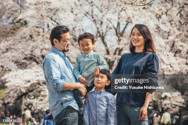 family portraits in front of cherry blossoms - family four people stock pictures, royalty-free photos & images