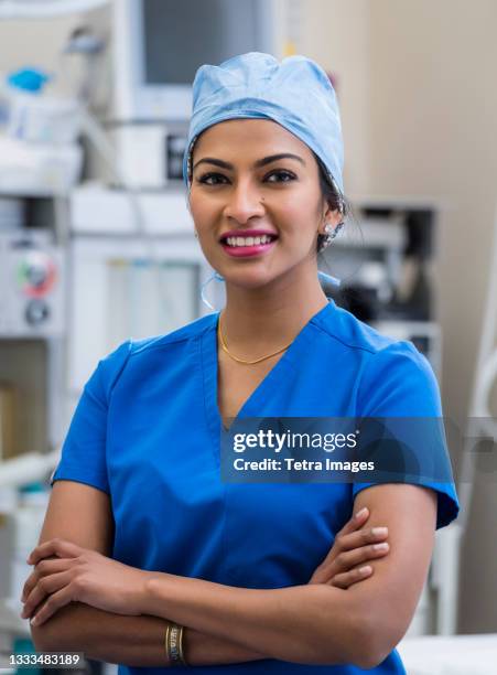 portrait of female doctor wearing scrubs - chirurgenkappe stock-fotos und bilder