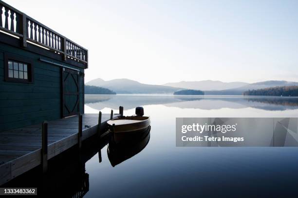 usa, new york, north elba, wooden boat docked on lake placid - lake placid stock-fotos und bilder