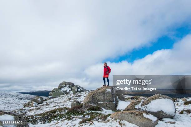 australia, new south wales, man standing on rock at charlotte pass in kosciuszko national park - australian winter landscape stock pictures, royalty-free photos & images