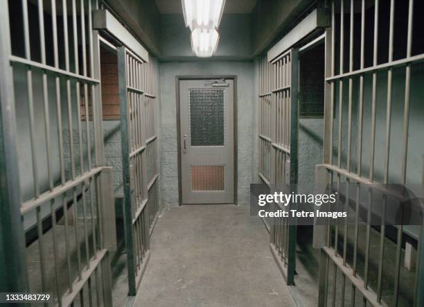 row of empty prison cells - jail cell foto e immagini stock