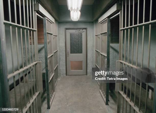 row of empty prison cells - gevangenis stockfoto's en -beelden