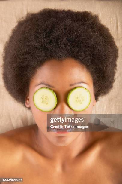 woman with cucumber slices over eyes - banc de massage photos et images de collection