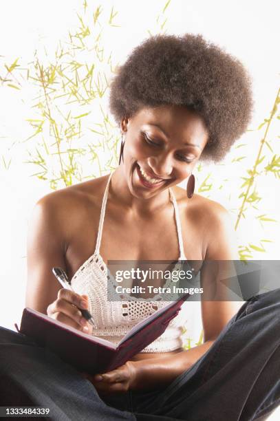 young woman in crocheted top writing in journal - feng shui stock pictures, royalty-free photos & images