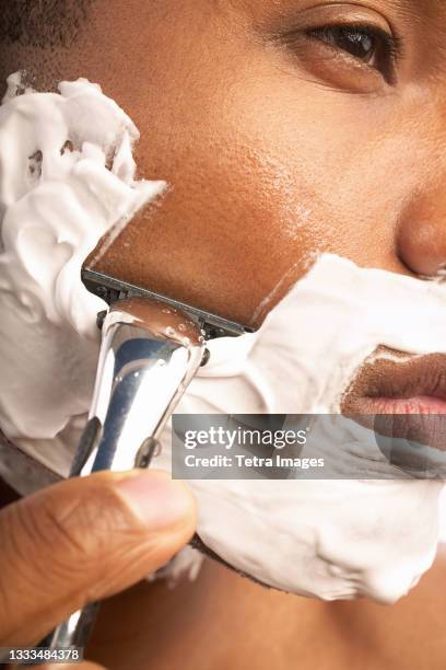 close-up of man shaving - man shaving face stock-fotos und bilder